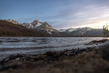 stanley lake during sunset from the beach with snow covered mountains in the sawtooth national forest in central idaho 