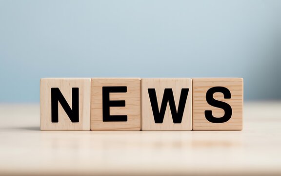 Four wooden blocks spelling NEWS arranged on a clean surface, symbolizing information and current events