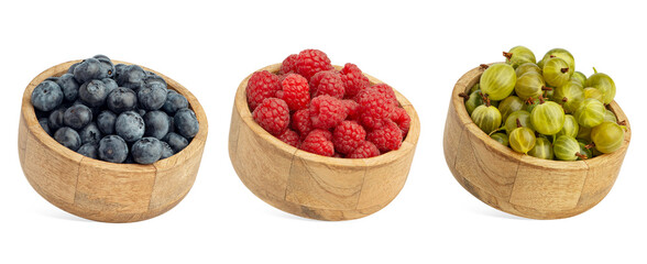 Summer berries in wooden bowls on a white background. Raspberries, currants, blackberries, gooseberries, blueberries, and blackberries.