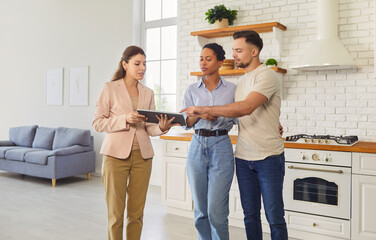 Consultation of couple with broker, real estate agent for home apartment purchase or lease planning. People meeting, using tablet for deal discussion, looking on screen. Property, advice concept