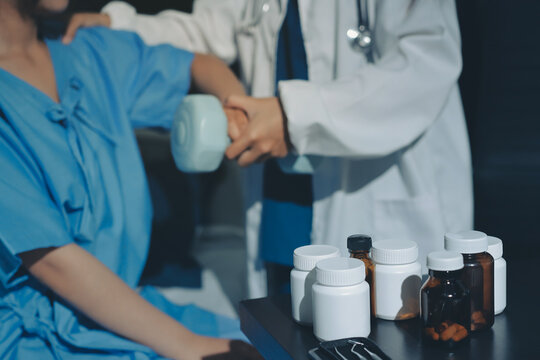 Physical therapist assisting a woman with dumbbell exercise - Powered by Adobe