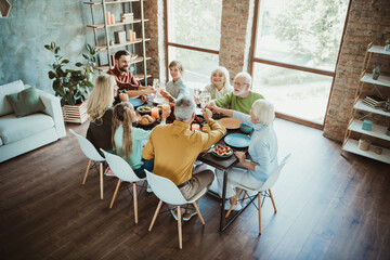 Funny warm family feast at a modern home celebrating Thanksgiving with grandparents parents...
