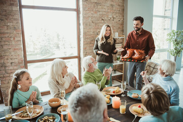 Funny heartfelt family gathering as they share a lively thanksgiving feast with turkey and warm smiles around the table