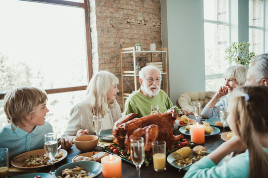 Fototapeta Fun family feast with turkey and laughter at a bright table a warm thanksgiving gathering with grandparents parents and kids