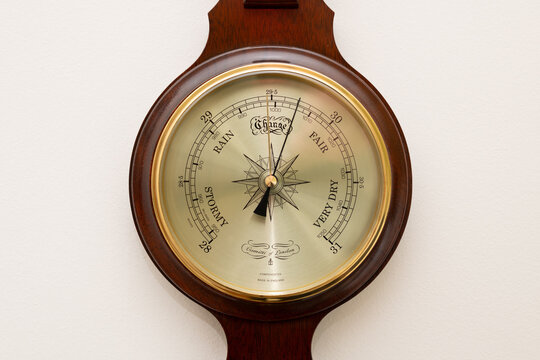 Close up of Comitti of London aneroid barometer mounted on a wall