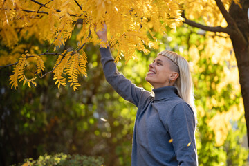 Woman enjoying autumn leaves in park