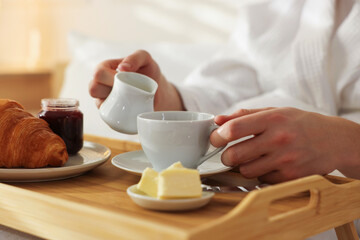 Man having delicious breakfast in bed, closeup. Hotel room service