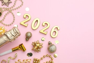 New 2026 Year. Golden numbers, shiny baubles, beads, confetti and bottle of sparkling wine on pink background, flat lay. Space for text