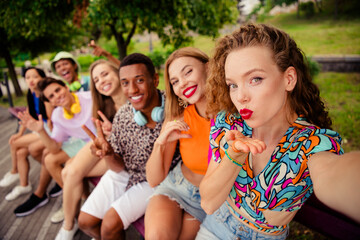 Group of diverse friends enjoying their summer break in a park with casual attire and joyful expressions