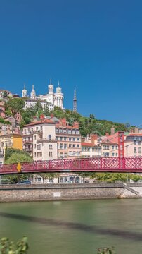 Timelapse hyperlapse of Saint George Church, Quais de Saone, and Fourviere Basilica from a footbridge in Vieux Lyon, France, showcasing historic architecture, reflections and a scenic river view
