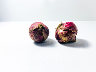 Fresh red onion isolated on white background. Red onion bulb on white surface. Fresh shallot minimal composition. Shallot isolated on bright background. Fresh red onion photography. Organic red onion 