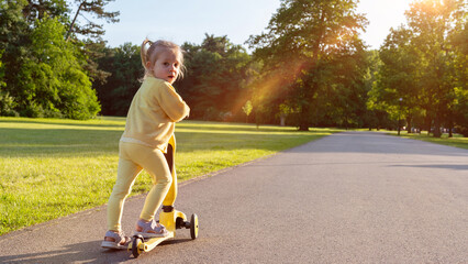 Child riding. Scooter toddler park play. Summer road motion casual sport.