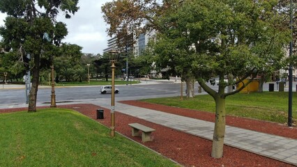 default
Wide shot of an empty street in downtown Buenos Aires, Argentina. The scene features tall buildings, including shops and residential units, lining both sides of the street. Prominent signs and