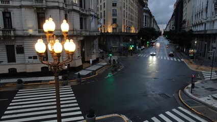 default
Wide shot of an empty street in downtown Buenos Aires, Argentina. The scene features tall buildings, including shops and residential units, lining both sides of the street. Prominent signs and