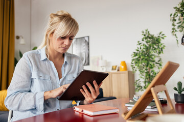 Woman working from home using digital tablet © MexChriss