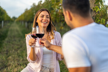 Couple toasting with red wine in a vineyard during a romantic date