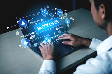 A professional working on a laptop with blockchain graphics displayed, illustrating the...