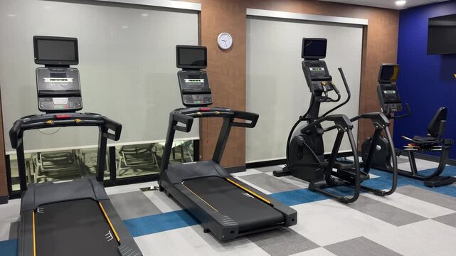 Titusville, Florida, USA, June 17, 2025: PAN SLOW MOTION - Treadmills, elliptical, and cycling machines in a hotel fitness center.