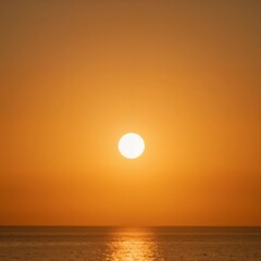Fototapeta premium Majestic sunset over calm ocean waters with warm orange hues 