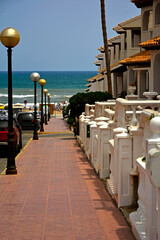 nadmorskie miasteczko w Hiszpani z domami i drogą na plażę, a seaside town in Spain with houses and a road to the beach	