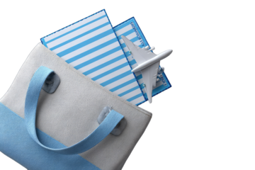 Light beige tote bag with blue straps, holding light blue striped papers and a white airplane model