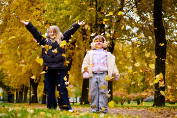 Children playing in autumn park with leaves
