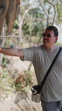 Man touching and feeding elephant at sanctuary