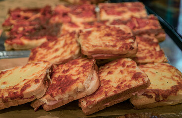 Freshly made croque monsieur sandwiches with melted cheese and ham on display at an artisanal bakery in the old town or Vieille Ville, Nice, France