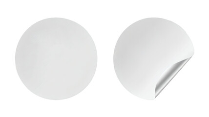 Blank white circular stickers ready for your custom design, one peeled revealing a metallic sheen, perfect for branding and labels