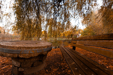 eine bank und ein stein tisch in einen park mit einen teich