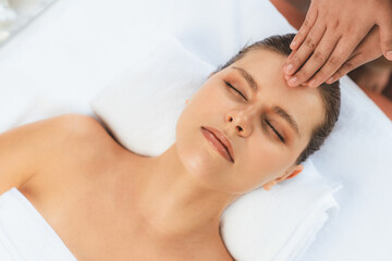 Panorama top view of woman enjoying relaxing anti-stress head massage and pampering facial beauty skin recreation leisure in dayspa modern light ambient at luxury resort or hotel spa salon. Quiescent