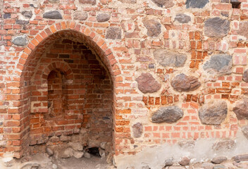 A close-up view of a historic brick building roof in Lubeck featuring two arched windows.