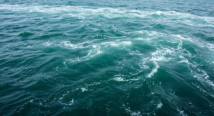 Fototapeta premium Serene ocean surface with rippling turquoise waves and white foam patterns