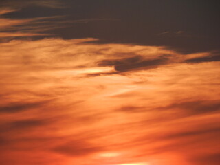 Dramatic sunset sky with fiery orange clouds, abstract natural background, warm glowing evening light