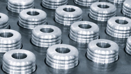 Quality testing of metal parts, round metal parts lying in rows on a quality control test table, industrial concept background.