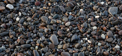 Wet  Pebbles stones on seashore as  texture background for design web banner template page. SPA concept background.