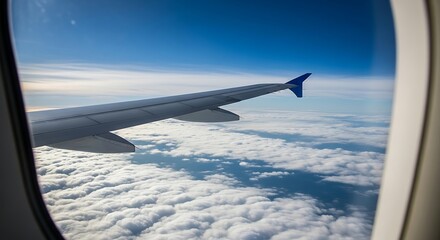 Obraz premium View of an airplane wing from the window, flying high above a sea of white clouds.