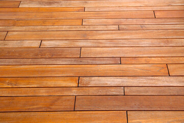 Fototapeta premium Outdoor ooden walkway surface with natural grain and warm brown tones.