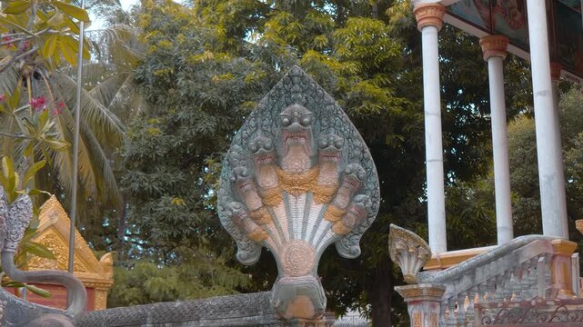 Seven headed serpent or naga statue guarding the entrance to Wat Svay Romeat Pagoda in Siem Reap, Cambodia. Shot in motion
