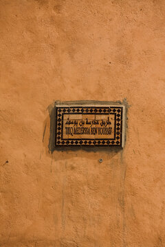 Marrakech, Morocco - 10.12.2024: Street Sign &ldquo;Triq Mederssa Ben Youssef&rdquo; on the Facade of Marrakech Museum, Morocco