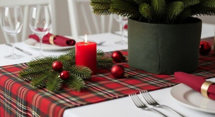 Plaidrunnered table set with a candle ornaments greenery plates silverware stemware  potted plant center piece