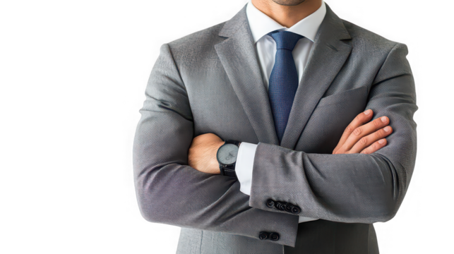 Man in a gray suit with arms crossed wearing a watch against a black background in a studio shot