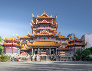 Fototapeta premium A Majestic Traditional Chinese Temple Architecture with Ornate Roofs and Red Walls Under a Clear Blue Sky
