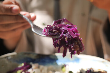 Enjoying purple cabbage on a fork in a bright setting