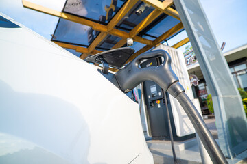 EV car charge outdoor electric station plug in rear view of car