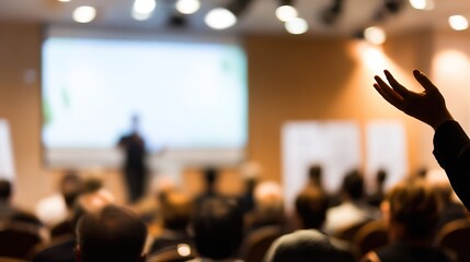 Audience member raising hand at conference, with speaker and screen in background, professional event scene, shallow depth of field, copy space