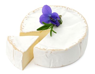 Close-up of a wheel of soft cheese with a wedge cut out, flower garnish
