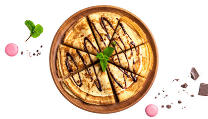 Overhead view of sliced crepes drizzled with chocolate, mint sprig, macarons, and chocolate bits