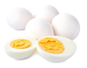 A cluster of white, whole eggs and two halved eggs with vibrant yolks
