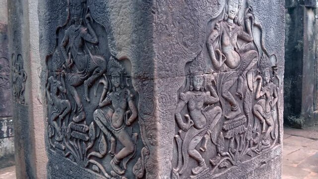 Stone bas-reliefs depicting beautiful dancing Apsaras skillfully crafted on the ancient stonecolumns and walls of the temple wall in Angkor Wat, Cambodia. Shot in motion